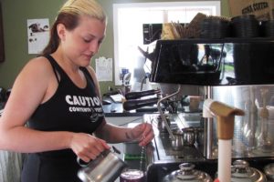 Paige McKnight, a barista at Michele's Coffee Corner, in Washougal, makes a white chocolate caramel mocha Monday. The "E" Street business, owned by McKnight's mother Michele, has experienced a decline in business due to the economy as well as recent roadwork. The "E" Street construction project, which involves conversion of the road width to two through-lanes and a center left turn lane, as well as bike lanes and sidewalks from Sixth to 32nd streets, is expected to be completed in September.