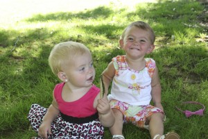 Sunni Lambert (right), 14 months, and Preslie Castellani (left), 11 months, grin for the camera while playing at Crown Park in Camas on Monday.  The girls recently competed in the Clark County Fair's Pretty Baby contest.  Preslie took first in her age group, while Sunni was picked first overall.  They are the daughters of longtime friends Brandie Castellani, of Camas, and Megan Lambert, of Washougal.