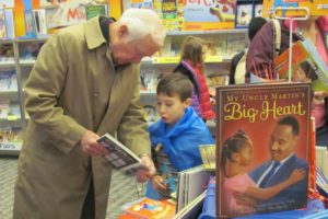 Sean Emberlin, 7, and his grandfather Bill Emberlin browse the selection at the Prune Hill Elementary School Scholastic book fair on Monday morning. The event is being held this week in conjunction with Superhero Costume Day and Grandparent Breakfast. In an effort to get everyone into the spirit of the event, masks and capes were available for students at the library. Other events this week will include story times with special guest readers and a live reptile show.