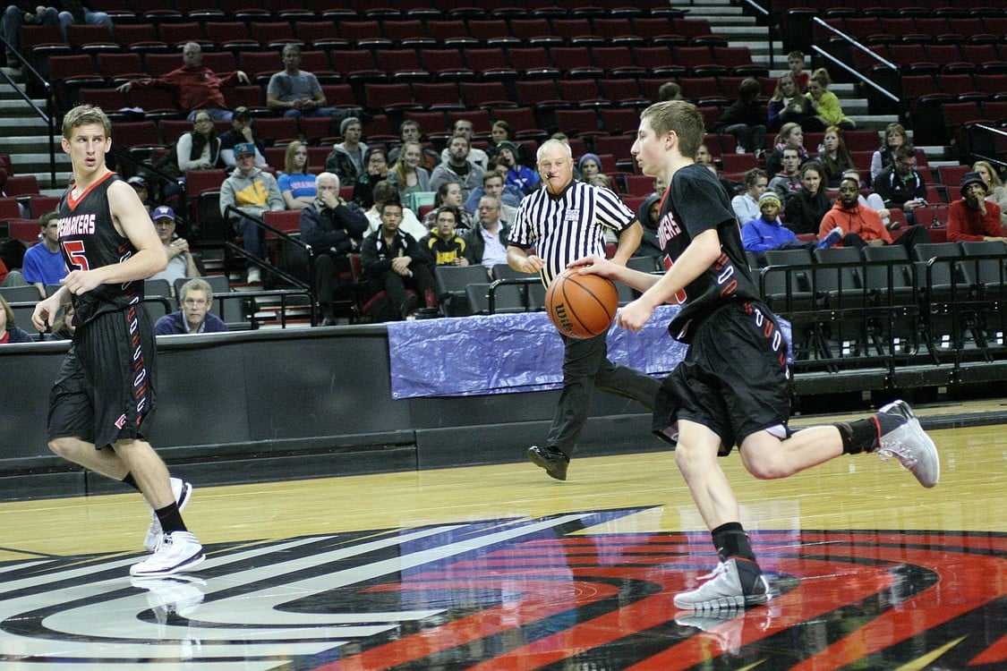Jake Hansel dribbles on the Portland Trail Blazer emblem.