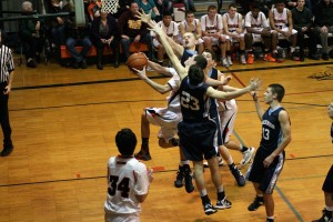 Three Hockinson defenders reach out in vain, but they are unable to stop Michael McElory. The Washougal High School senior racked up 20 points on "Senior Night," which helped the Panthers beat the Hawks 61-51.