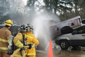 Photos courtesy of ECFR
Citizen Academy participants Martha Martin and Sheila Plato work with ECFR Intern Fire Fighter/EMT Reece Bonenfant to extinguish a fire in the cab of a pick-up truck.  The group learned how to handle charged fire hoses while safely approaching vehicle fires.  Exploding pressure cylinders in "low impact bumpers" can seriously injure emergency responders as firefighters approach vehicles at angles to avoid flying bumpers and rocketing cylinders.  The 1.75-inch fire hoses, used to extinguish vehicle fires, deliver 180 gallons of water per minute at a nozzle pressure of 100 psi.