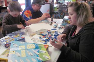 Dave and Becky Dotson, and their son David Jr., enjoy playing with Legos at their new store in Washougal, Hero Support. The business, which opened today, buys, sells and trades Pokemon, Yu-Gi-Oh and Magic: The Gathering cards, and sells role playing games and Star Wars, Simpsons and Avengers collectible figures.