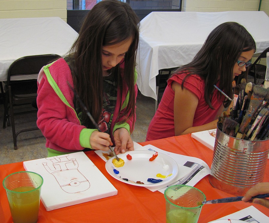 From left, Alyssa Dawson and Kelsey Osmus paint their one-eyed minions during Art Van Go class. Both have attended Field's classes before.