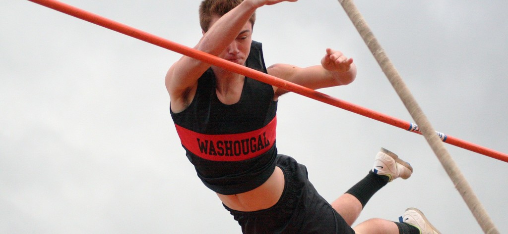Adam Thomas soars over the bar set at 13 feet for the first time this season to earn second place in the pole vault during the 2A district track and field meet Friday, at Fishback Stadium.