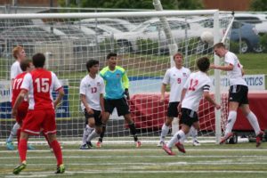 Matt Palodichuk defends a shot taken by Ferris in the state quarterfinal game Saturday, at Doc Harris Stadium. Riley Brannon, Calvin Goon, Sharif Batroukh, Lucas Ulmer and Austin Cassity keep a cautious eye on the action.