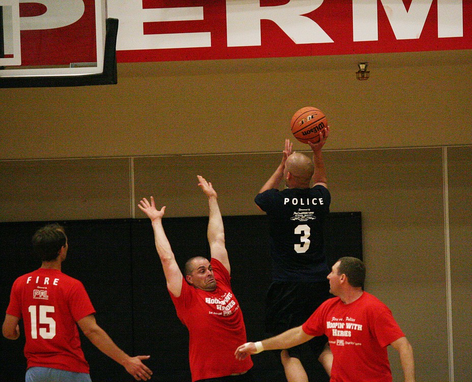 Josh Troyer takes a shot during the first Camas-Washougal Hoopin' With Heroes Fire vs. Police charity basketball game Friday, at Camas High School. Spectators brought enough cans of food to fill six boxes, which was donated to the Inter-Faith Treasure House in Washougal.