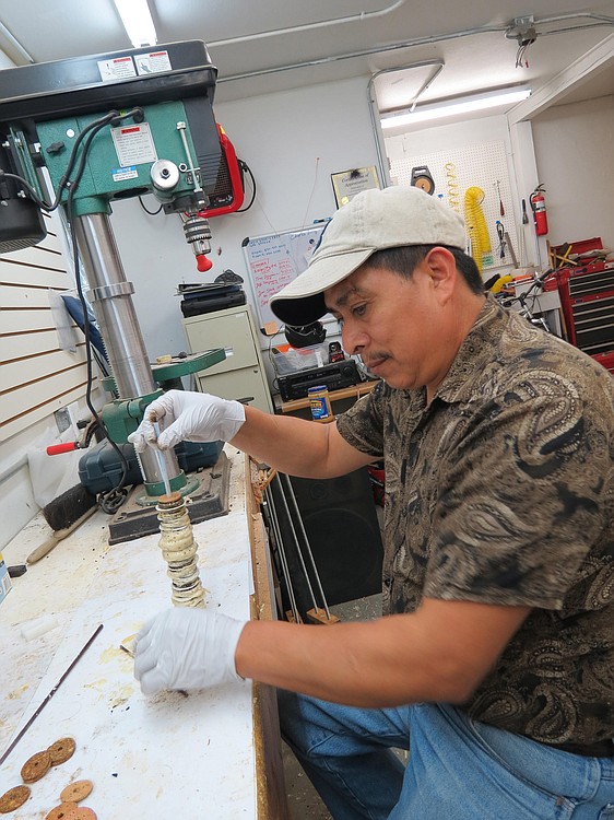A C.F. Burkheimer fly rod designer glues pieces of wood together to make a handle.
