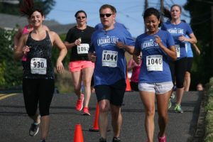 A pack of Lacamas Lake Half Marathon and 5K runners head down the hill on Dallas Street toward the finish line on Fourth Avenue Sunday.