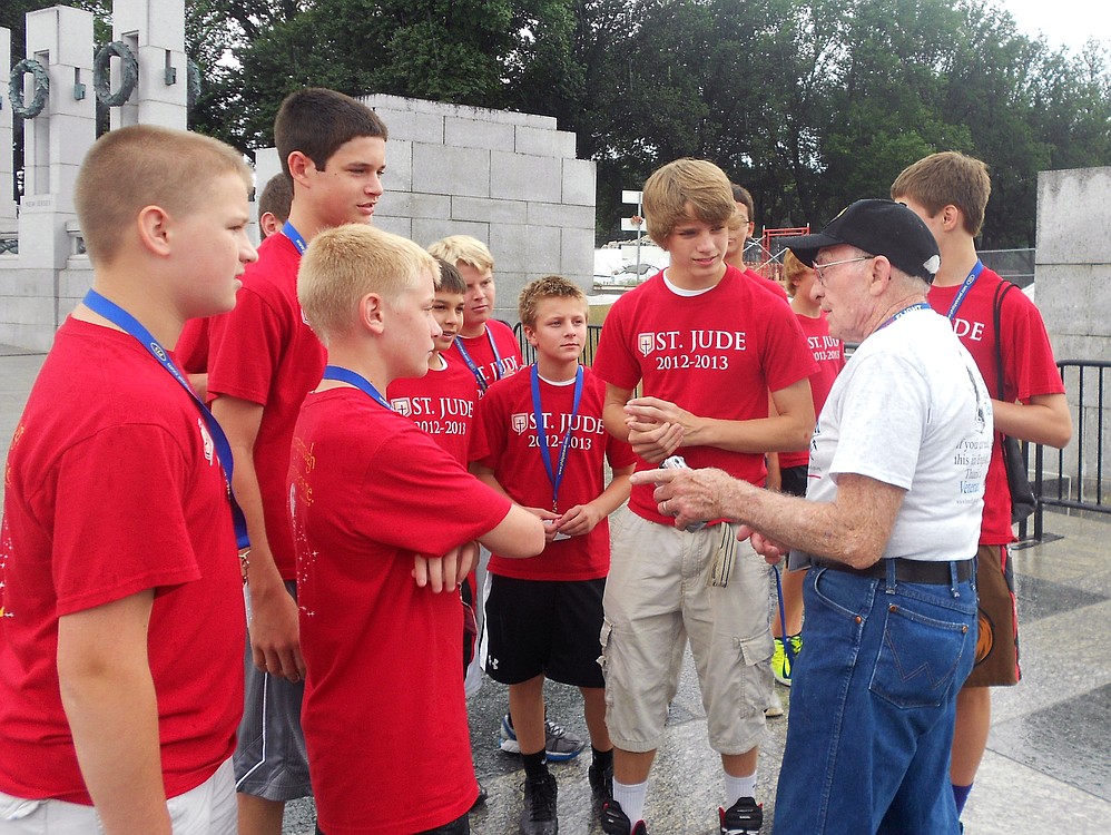 Wilbert Kalmbach, a participant in the Honor Flight program, talked to several eighth grade students. He told them knowledge is useless unless it is shared, and skill breeds success. "So autograph your work with excellence," Kalmbach said. His daughter, Maria Dunn, served as his guardian during the trip. There was no cost to Kalmbach or the other veterans, while the guardians each paid $400.