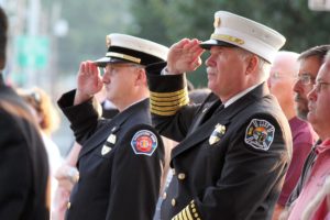 Washougal Fire Chief Ron Schumacher (right) and Longview Battalion Chief Kevin Taylor (left) stand at attention as Camas Battalion Chief Allen Wolk and Camas Fire Capt. Chuck Bettis (not pictured) raise the American flag to half-mast in front of the Camas Public Library Sunday morning, in recognition of the 10-year anniversary of the Sept. 11, 2001, terrorist attacks.