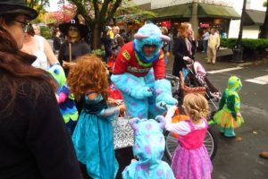 Camas Bike & Sport co-owner Ed Fischer gives candy to children during Boo Bash Wednesday.