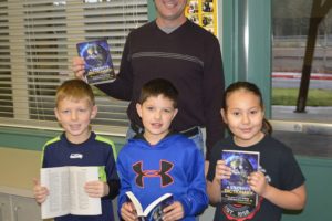 Rotarian John Spencer stands with Cape Horn-Skye third-grade students Brody Davis, Lincoln Connelly and Ellison Wilkins while they display their new dictionaries.