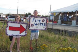 Camas High School seniors Emily Conner and Konner Lessard help advertise the fireworks stand located on 192nd Avenue and First Street in Camas on Thursday. Owned by Gene Marlow, a portion of the proceeds will be donated to Camas High School and Union High School.