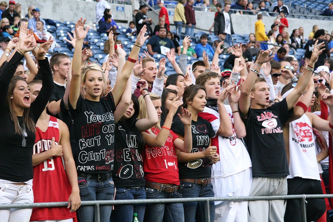 Camas football fans throw their hands up after performing the "Hand Jive."