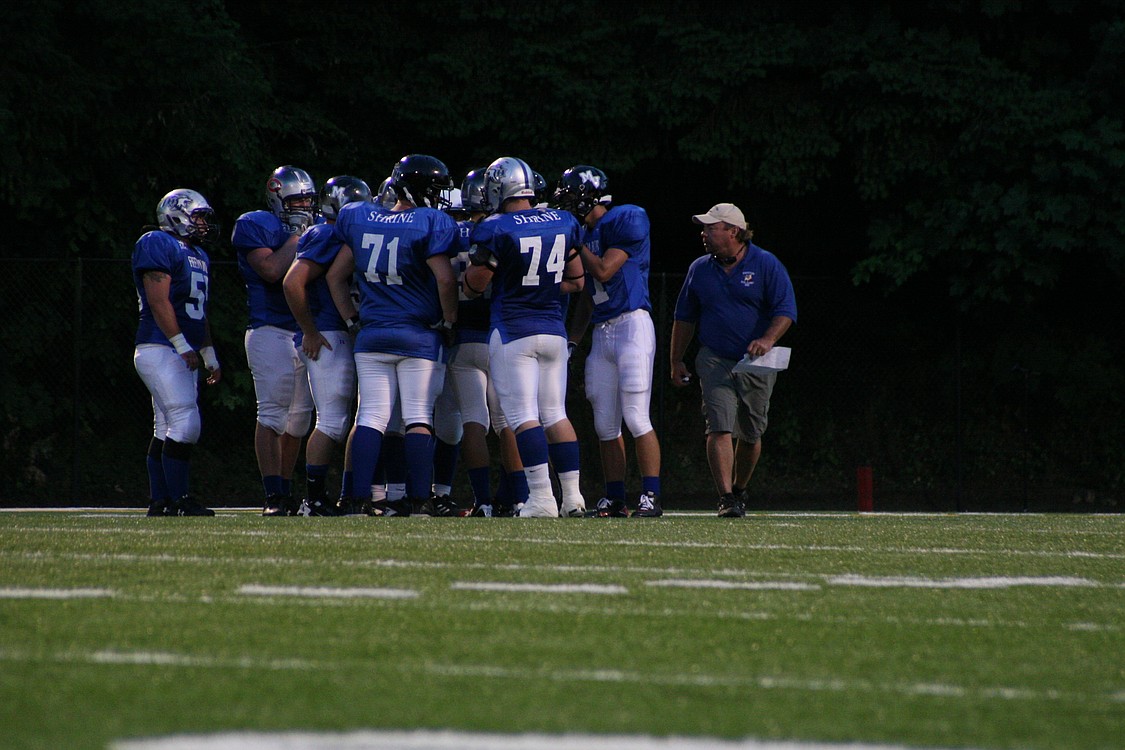 Washougal High School football coach Bob Jacobs goes over a play with the East All-Stars.