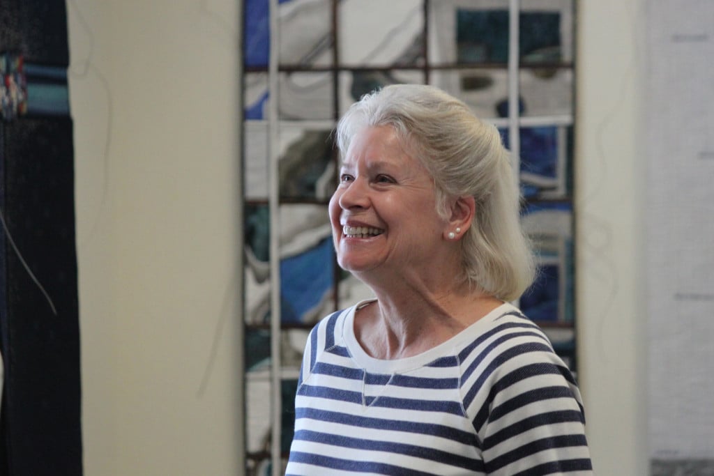 Tulla Burke jokes with fellow volunteers as they work to set up "What's Blue to You?" A show featuring the work of High Fiber Diet," a group of fiber artists from both sides of the Columbia River. They meet and devise a challenge each year that gives them strict boundaries--such as size or color--and wide interpretation.  Their work is juried before sending it out into the world. 