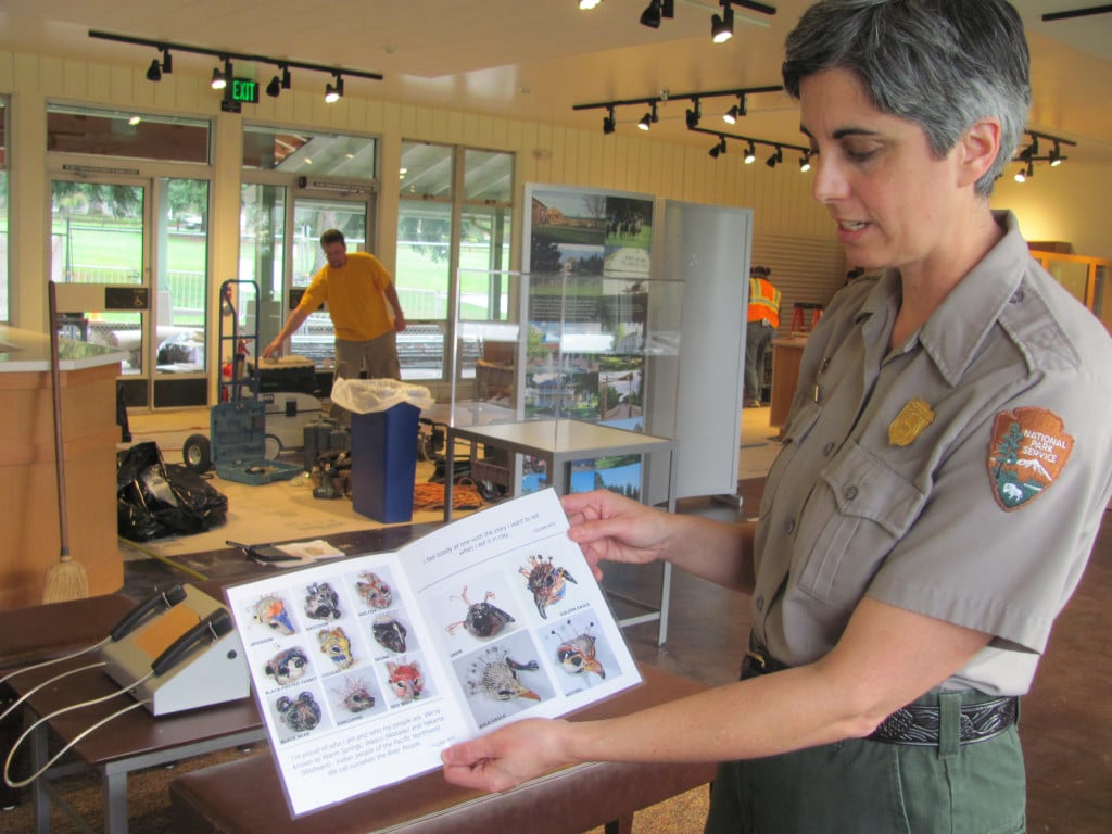 Curator Theresa Langford shows a brochure from artist Lillian Pitt, who will be featured at the vistor center. Different artists' work will rotate through the new center, which opened to the public Saturday. 