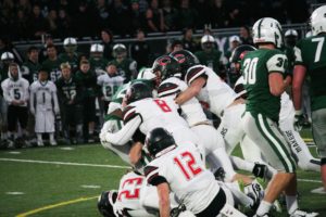 Six Camas High School football players plow into Skyline running back Rashaad Boddie in a state quarterfinal game Saturday, in Sammamish. The Spartans defeated the Papermakers 35-10.