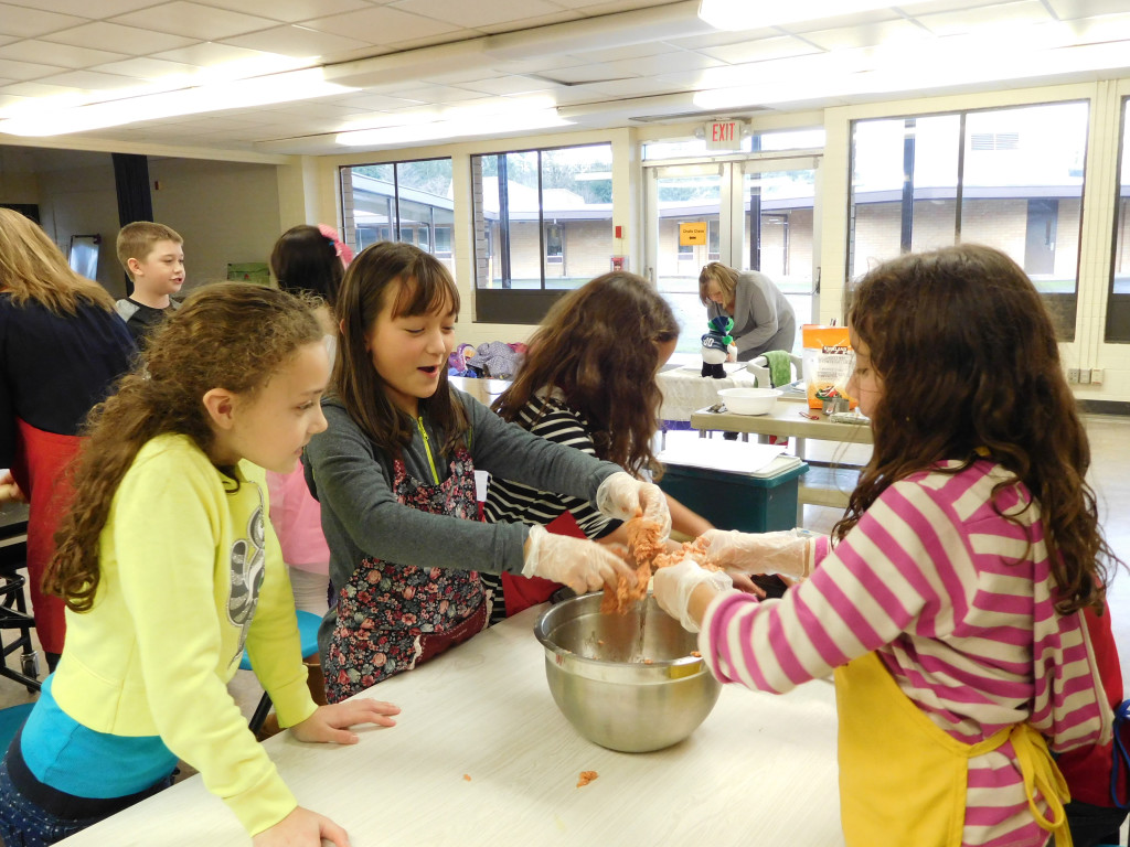 Kierra Thompson, Jasmine Bergstrom, Sophie Schuett and Helena Schuett mix spicy sausage with cheese and rosemary to make cheese balls.  