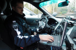 Camas Police Officer Casey Handley uses a laptop computer in his patrol car to view the locations and descriptions of calls that have been dispatched. He is a former WPD reserve officer.