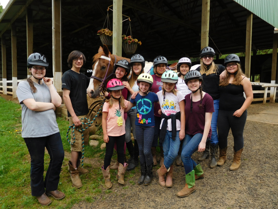 Students at Son Rise Ranch pose with Cisco, the oldest of the ranch's 14 horses. He has been a fixture there for 22 years, and served more than 100 equestrians.