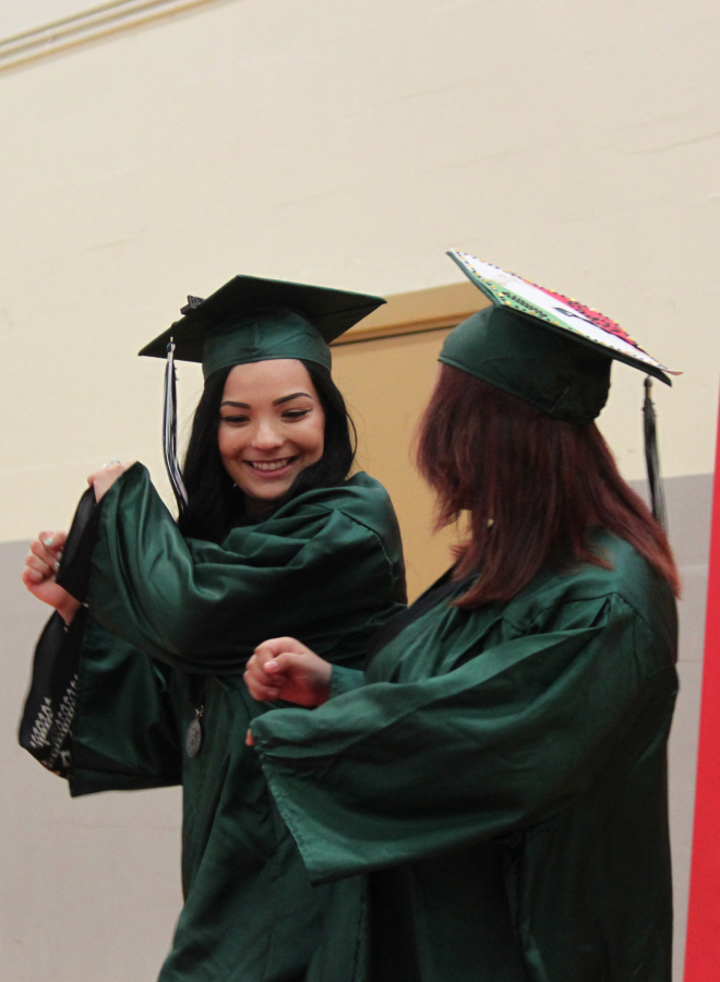 Each Hayes Freedom High School students Cassie Russell (left) and Ilse Villasenor (right) put their own twists on their entrance into the Liberty Middle School gymnasium on Saturday. 