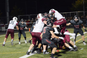 Camas football players catch the Sherwood running back trying to leap into the end zone Friday, at Doc Harris Stadium.