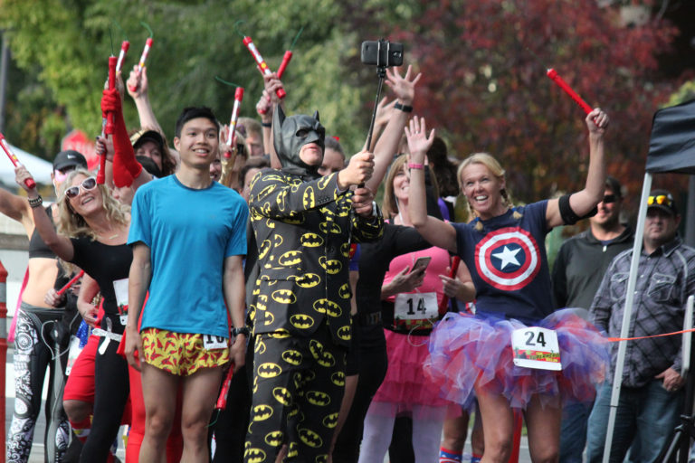 Dressed as Batman, Get Bold Events Executive Director Elba Benzler Jr. captures a selfie prior to the start of the 15K Superhero Relay on Saturday night in Washougal. Teams of three runners, dressed in hero and villain costumes, each ran a 5K leg that began at Pendleton Woolen Mills and continued along the Dike Trail. Taking home the $150 prize as the fastest team was Joe Dudman, Anthony Lee and Gary Daubenspeck, who completed the relay in 56 minutes, 54 seconds. A team from Washougal dressed as Charlie's Angels won for best costume, an honor that was determined by crowd applause at the nearby Oktoberfest at Reflection Plaza. Benzler said plans are already in the works for next year's race, which will once again be held in conjunction with Oktoberfest. In addition to the relay, the 2017 event will also feature a Superhero Kids 1K.