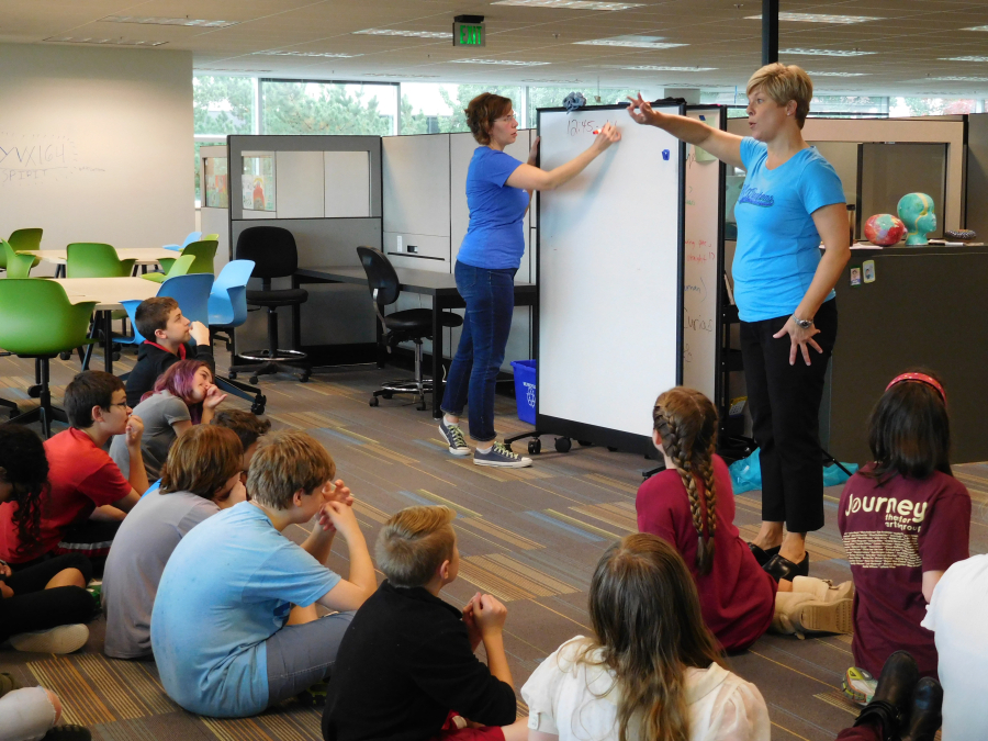 Seventh-grade teachers Lisa Wilderman, right, and Tiffany Morrisey work with students before they break into small groups for the afternoon. 