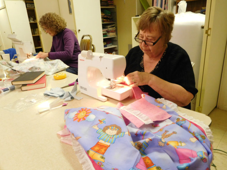 Linda Christensen (left) and Sherry Spiekerman (right) sew pockets onto dresses for Hope 4 Women International's "Dress a Girl Around the World" program.