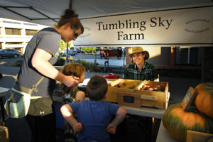 Farmer Tyson Weaver, of the Washougal-based Tumbling Sky Farm, tells local children about his seasonal veggies at the Camas Farmer’s Market. Contributed photo by Tina Eifert