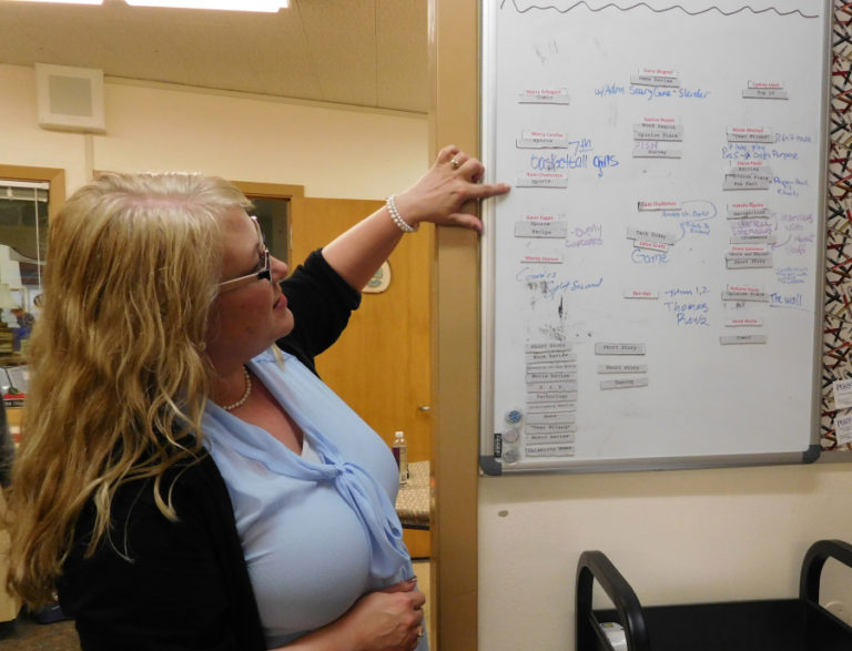 The newsroom in Emily Crawford&#039;s journalism class includes a whiteboard with different story assignments for her young reporters.
