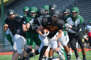 Nathan Tofell bursts through the battle lines of Panthers and Plainsmen to score a touchdown for Washougal in a scrimmage game against Evergreen Tuesday, at McKenzie Stadium in Vancouver. 