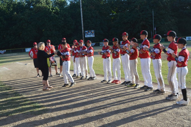 The Camas Little League 11- and 12-year-old baseball all-stars collect their district championship medals.