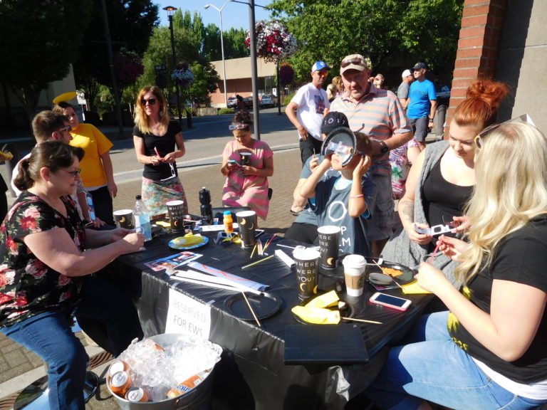 Employees of Effective Web Solutions, of Washougal, moved their office outside to view the eclipse from Reflection Plaza Monday morning. (Photo by Dawn Feldhaus/Post-Record)
