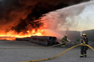 Camas-Washougal Fire Department firefighters attack a commercial fire burning through a storage yard in Washougal in July of 2017. (Post-Record file photo)