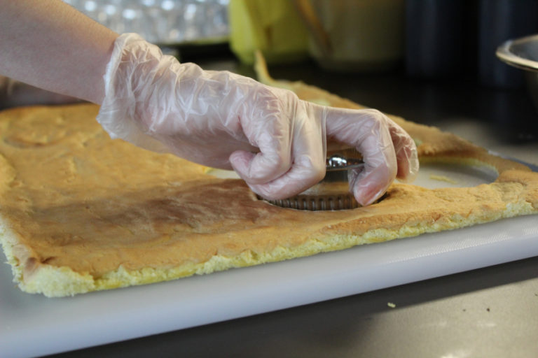 The advanced culinary students prepared layers of sponge cake the day before assembling the tiramisu cups.