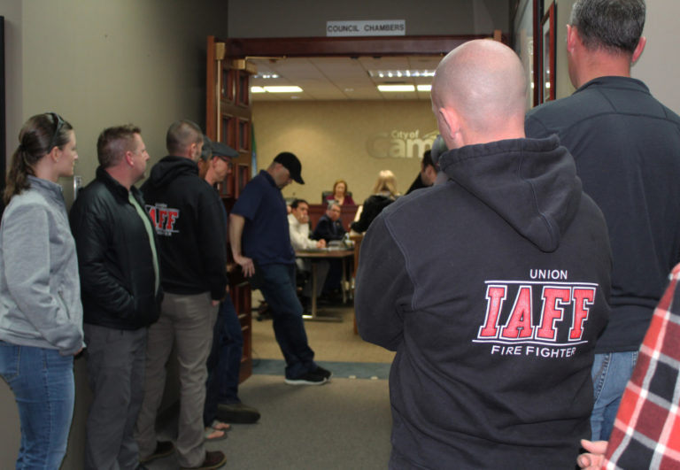 Firefighters wait inside the front lobby of Camas City Hall on Monday night, waiting for a turn to address the Camas City Council about putting more than two firefighters on an engine for all types of calls, after a fatal house fire in mid-February claimed the life of a Camas man and, according to firefighters, endangered the two first responders who responded to the call.