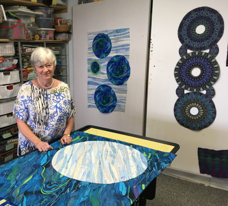 Camas quilter Dianne Kane stands in her studio, near two of her art quilts. The quilt on the left is called "Moons Over my Bathtub," and is one of seven quilts Kane will show in the upcoming Clark County Quilters' 43rd annual Quilt Show, April 5-7, at the Clark County Event Center. Kane, along with another local quilter, Wilma Scott, is co-chair of this year's quilt show.