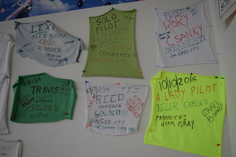 The tails of former student's shirts are hung on the walls of ATC Camas, located at Grove Field in Camas. It is tradition for students to take this portion of their shirts, date them and sign them when they qualify for their private pilot's license. (Tori Benavente/Post-Record)