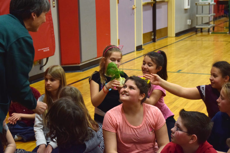 Sharon Whalen, from Duck Delivery Produce, talks about the ways fennel can be added into students diet while they pass around and smell a bulb of the vegetable, during the Well-Being Fair at Hathaway Elementary School on April 20.