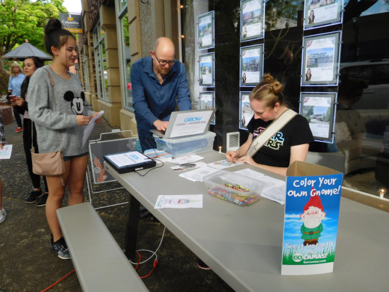 Ron Johnson (center) scans images of gnomes and posts them online after children and teens color them during the May 4 First Friday event in downtown Camas.