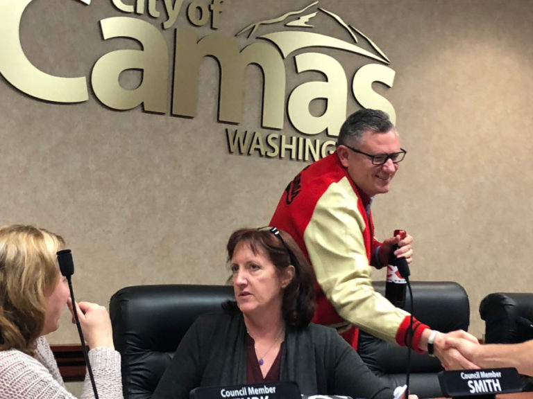 Camas Mayor Scott Higgins (right), wearing his Camas High letterman's jacket and holding his trademark Camas Papermakers water bottle, shakes hands with well-wishers after the Monday, June 11 city council work session, in which he announced his unexpected resignation, effective Sept. 30. Also pictured: Camas City Council members Shannon Turk (left) and Melissa Smith (center).