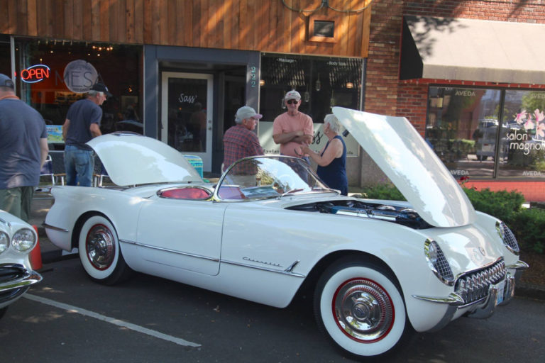 Steve Chaney (third from right) leans against his restored 1954 Chevy Corvette at the 2017 Camas Car Show. The pristine convertible, restored using all original parts, took home the Best in Show prize at last year's car show.