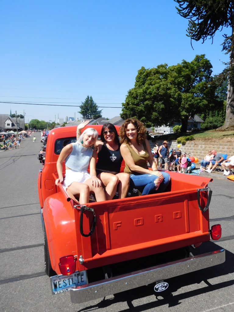 Dawn Stanchfield (center), the Camas-Washougal Chamber of Commerce 2018 “Business Person of the Year,” enjoys participating in the Camas Days Grand Parade, Saturday, July 28. Stanchfield, owner of Lily Atelier, in downtown Camas for 15 years, has provided clothing for fashion shows that benefitted CDM Caregiving Services and Second Step Housing.