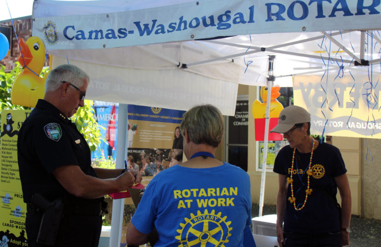 Camas Police Chief Mitch Lackey (left) adopts a duck for the annual Camas-Washougal Rotary Club's Ducky Derby fundraiser. The rubber duck that travels the fastest down the Washougal River from the Third Avenue Bridge in Camas at noon, Sunday, July 29, will win its lucky "adoptive parent" a week-long trip to Hawaii.