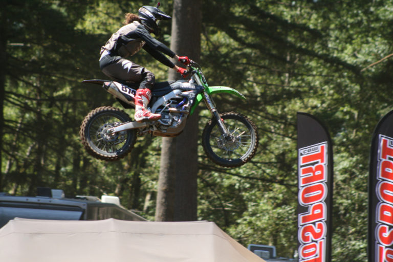 A pro motocross rider goes airborne next to the trees during the Washougal National at Washougal MX park on Saturday, July 28