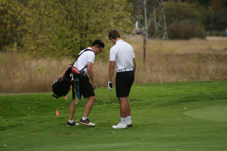 Camas golfers Andrew Kwon and Derek Harker search for a ball plugged in the mud on hole 2, at Camas Meadows, during a Sept.