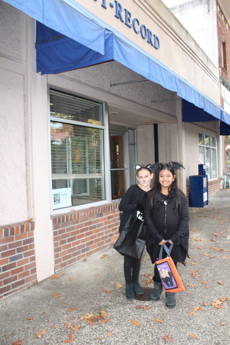 Prune Hill Elementary third graders Kamryn Cluer (left) and Elise Triplett (right) stop in front of The Post-Record office during the 2018 Boo Bash event in downtown Camas, Oct. 24.